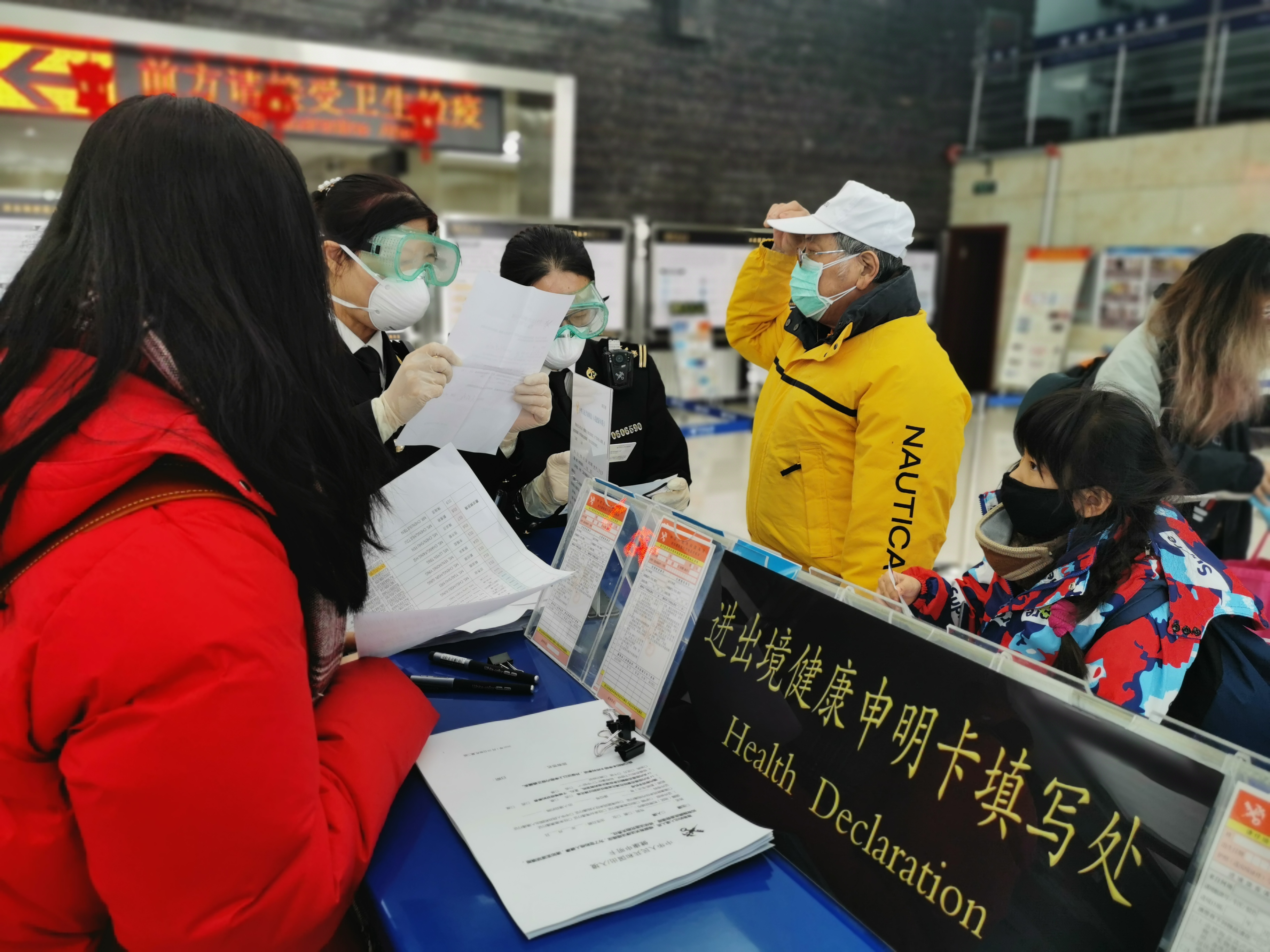 图为:海关关员指导旅客填报健康申明卡.jpg